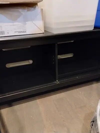 Black Entertainment Console. Has two glass doors, and two shelves for storage. The stand is black an...