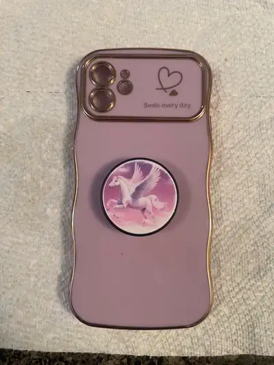 This is a used iPhone 12 case featuring a fun design with a unicorn pop socket for added grip. The c...