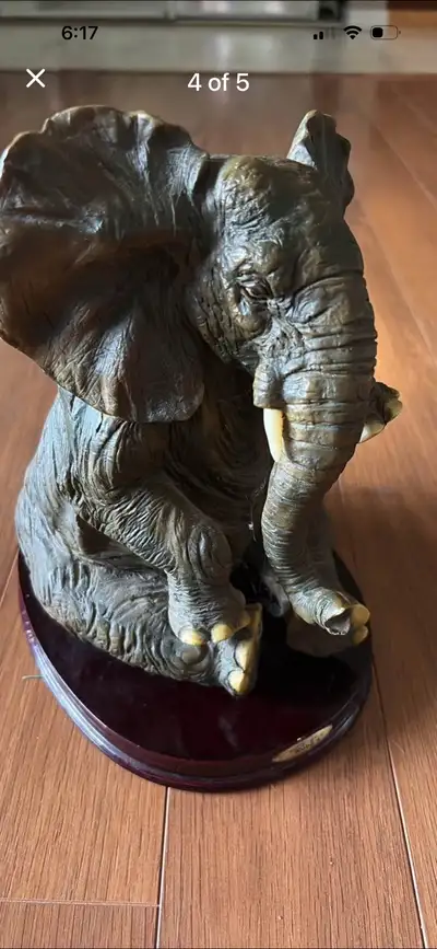 This is a figurine from Ruba's Collection, featuring an elephant in a seated position. It is a detai...