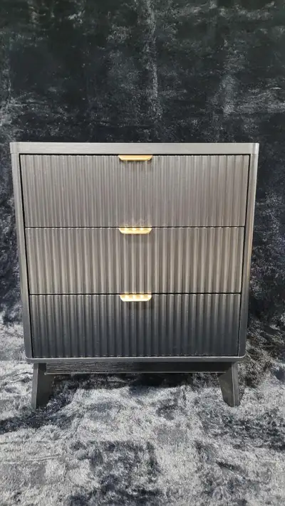 This stylish three-drawer night table features a modern black finish with fluted drawer fronts and e...