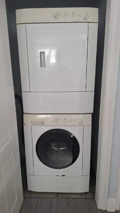 Voici une laveuse et sécheuse superposées qui offre une solution pratique pour les petits espaces sa...