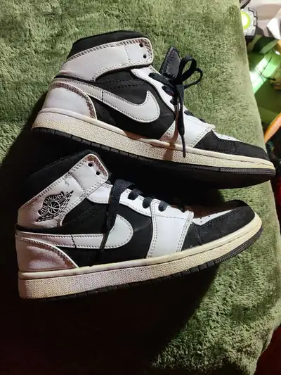 These are a pair of used Jordan 1 Mid shoes in a black and white colourway, perfect for basketball o...