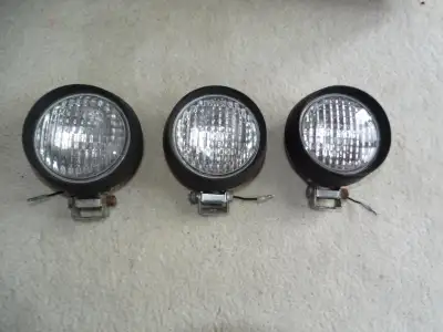 Three 4 inch halogen driving lights. Rubber body, glass lens. Dimensions: 6"H x 5"W x 3"D