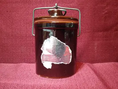 Brown glaze. Measures 5 inches tall, 3 1/4 inches wide. Some of the original label is still attached...