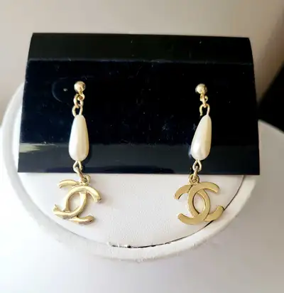 These are new pearl drop earrings with a gold Chanel logo. They are a lovely addition to any jewelry...