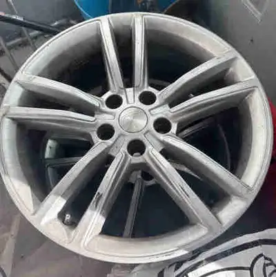These set of four Tesla alloy rims are in good working condition but show signs of wear, including s...
