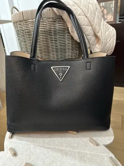 This is a like new GUESS tote bag, perfect for everyday use with its sleek black design and ample st...