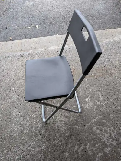 This pre-owned Cosco folding chair features a durable black plastic seat and backrest supported by a...
