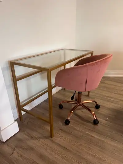 This is a gently used luxury desk with a glass top and gold frame, paired with a stylish pink velvet...