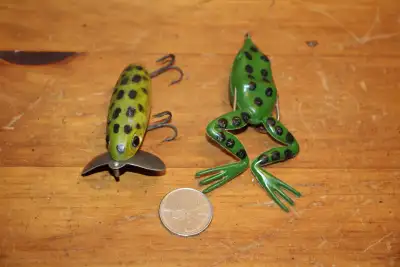 Pair of vintage fishing lures. One is a rubber frog and the other is marked "Jitterbug. Mfg'd by Fre...