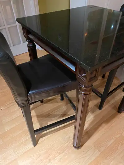 Table avec dessus en granit, la table est en excellente condition. Les 2 chaises de style tabouret e...