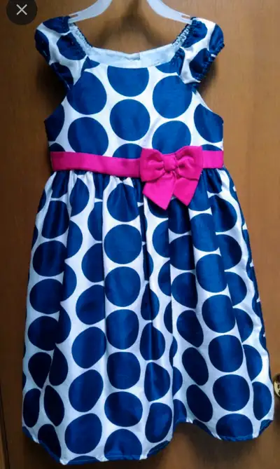 Girl's size 5X white dress with large navy blue polka-dots and pink bow. Dress comes with attached s...