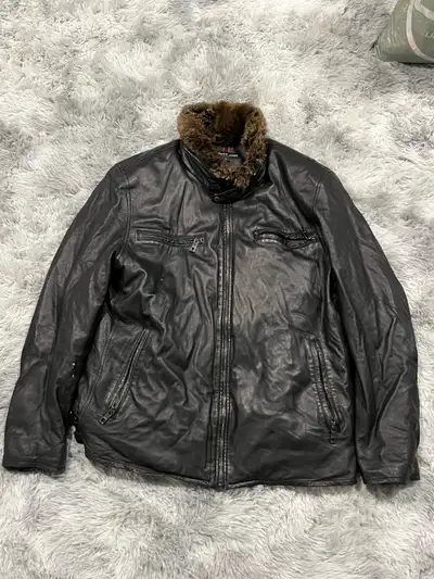Elevate your style with this striking Andrew Marc black leather jacket, featuring a luxurious fur co...