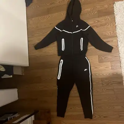 This is a Nike tracksuit in new condition. It's a stylish and comfortable set, perfect for workouts...