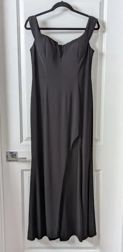 Long elegant black evening gown featuring a fitted lined bust & a long slit up the left side. Size 1...