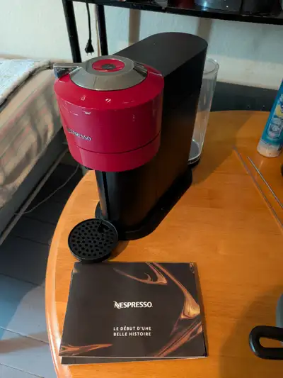 Il s'agit de la machine à café et espresso Nespresso Vertuo Next de couleur rouge, accompagnée de so...