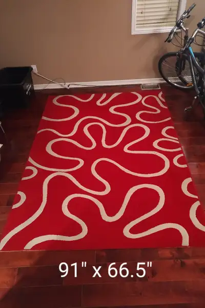 A sturdy, cheerful red and ivory squiggle pattern IKEA LONNI rug. This is a very thick and dense rug...