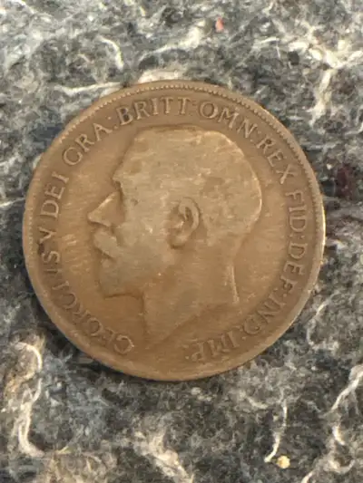 This is a 1921 One Penny coin featuring King George and Britannia. Given its age, this coin shows we...