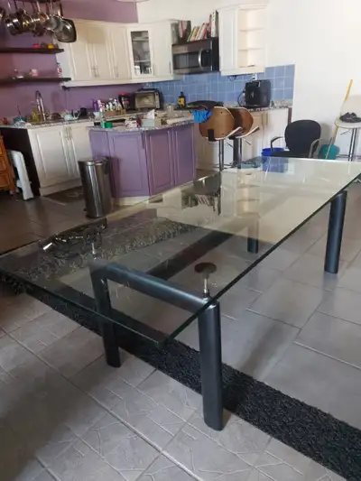 Thick/heavy tempered glass table top with a 4 legged, industrial look, height adjustable steel base....