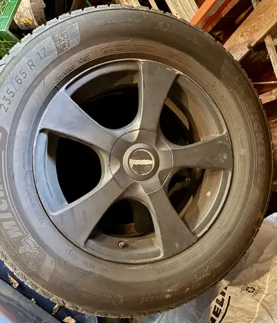 For sale is a set of Michelin X-Ice Snow winter tires, size 235/65R17, mounted on alloy rims. The ce...