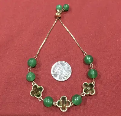 Adorn your wrist with this enchanting green beaded bracelet, featuring clover accents and an adjusta...