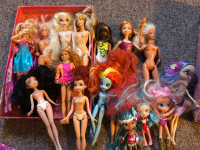 Set of barbies, clothes, and a barbie storage box