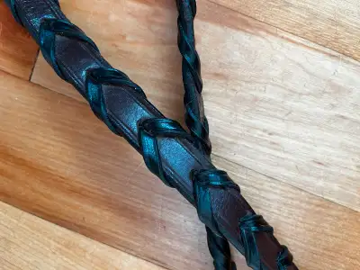 Supple brown reins with accented black leather laced grip. Width: 5/8 inch Length: 57 inch Hook and...