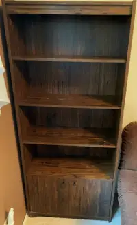 Twin bookcases with covered storage space at bottom