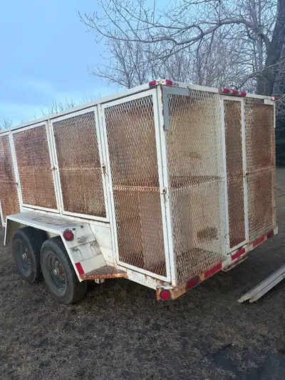 Solid dual axle utility trailer with full steel mesh cage sides, built for hauling landscaping debri...