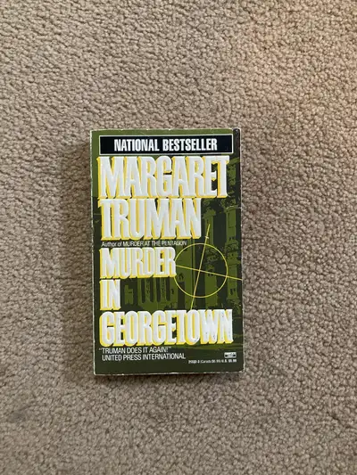 Margaret Truman’s Murder In Georgetown. Fairly old, but good condition - faded pages, some folds, bu...