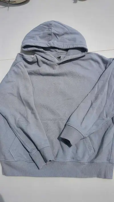 Get cozy with this New Balance blue grey hoodie, perfect for throwing on after a workout or for a ca...