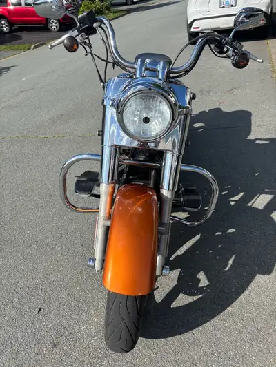 Vibrant orange Harley-Davidson Dyna Switchback with a chrome finish. This motorcycle has hard-shell...