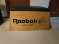 Vintage wood shoe store bench with Reebok promo Logos