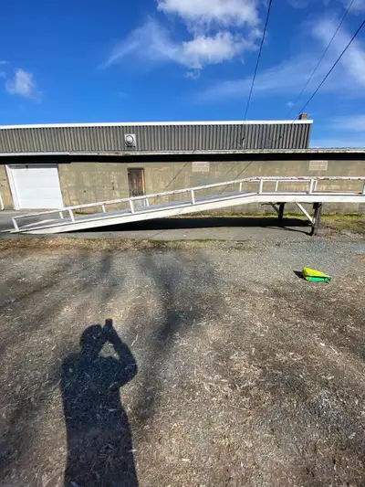 This is a used steel ramp, approximately 30 feet in length, with an adjustable height feature contro...