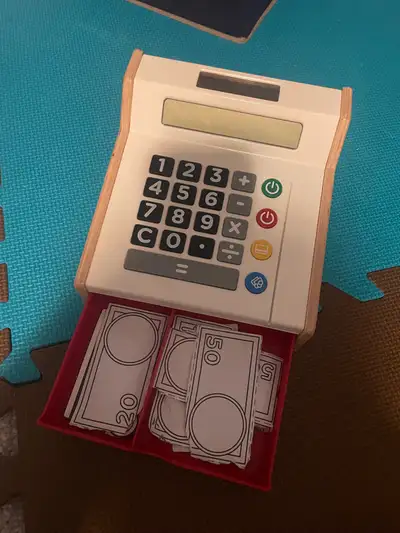 Toy cash register that opens with paper money. Does not make noise—it’s an old school classic toy th...