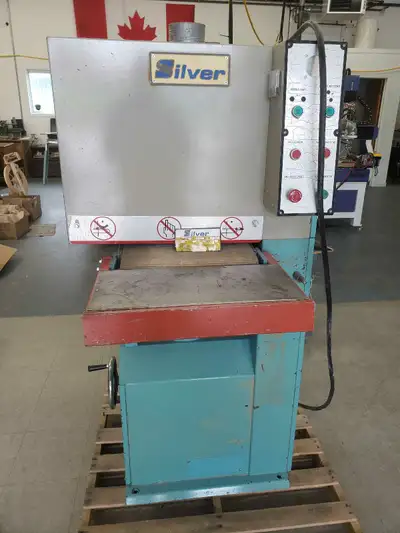 Silver 16" oscillating belt sander, equipped with a 5 HP, single-phase 220V motor. Should be on a 40...