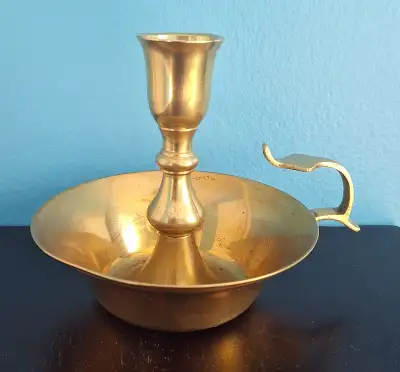 Vintage brass candlestick holder with a convenient handle. Measures about 6 inches tall.