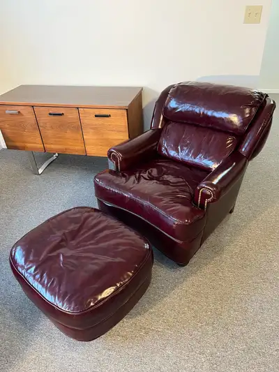 Vintage leather armchair with matching footstool. Wine colored (burgundy) high quality leather every...