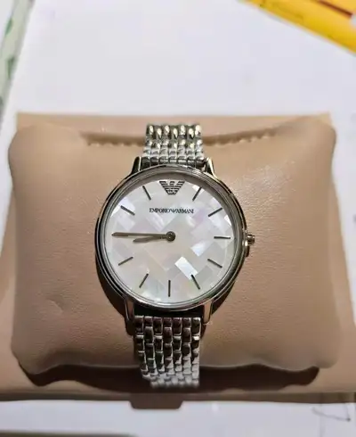 This is an elegant Emporio Armani Kappa ladies' watch, featuring a stylish silver band and a mother-...