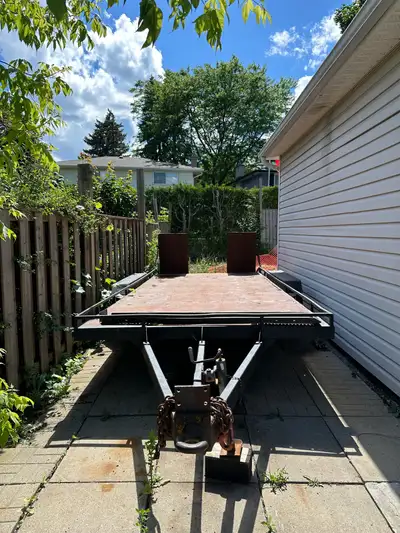 Solid steel two axle car trailer with steel ramps, axles are 5000lbs each n it has some holes in dec...