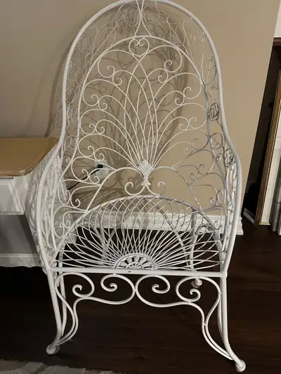 This white metal chair features a beautiful peacock design, perfect for adding a touch of elegance t...