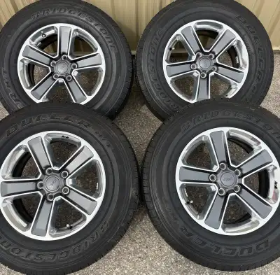 BRAND NEW CONDITION 4 x 255/70/18 113T BRIDGE STONE DUELLER H/T ALL SEASON TIRES AND OEM JEEP WRANGL...