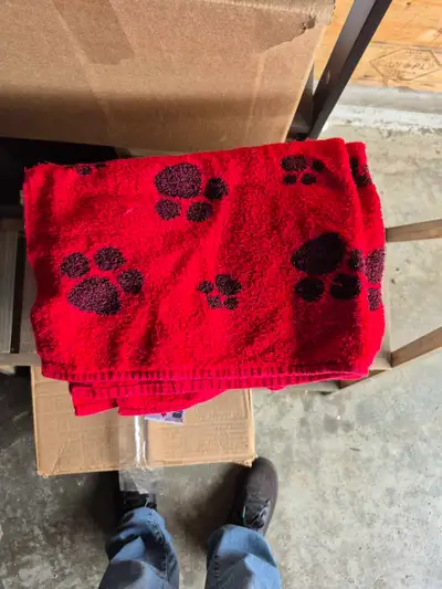 This gently used red dog towel with black paw prints is perfect for drying off your furry friend aft...