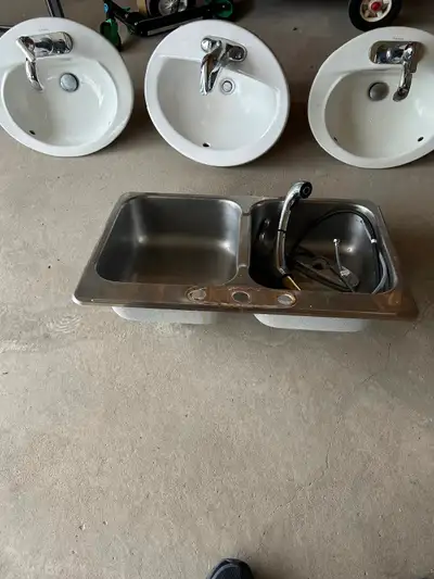 One kitchen double bowl sink. 31 x 21. 4 American standard washroom sinks with faucets. $20 each.
