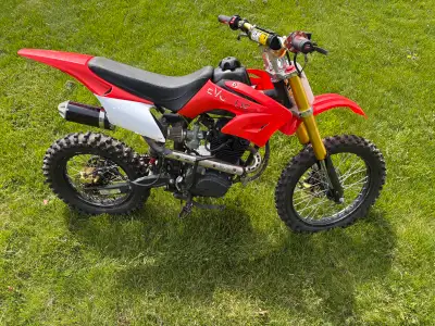 Get ready to tear up the trails with this vibrant red 150cc dirt bike, perfect for beginner riders s...
