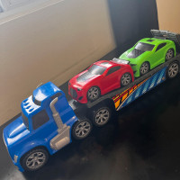 Flatbed tow truck with red and green sportscars