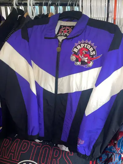 Authentic 1990’s Toronto Raptors NBA windbreaker jacket featuring the original dinosaur logo from th...