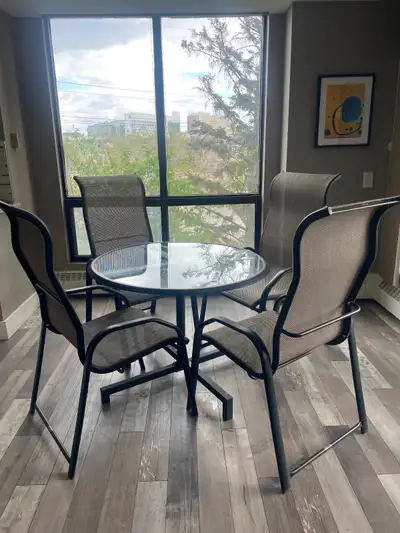 This used patio set features a 39-inch round glass-top table, accompanied by four comfortable chairs...