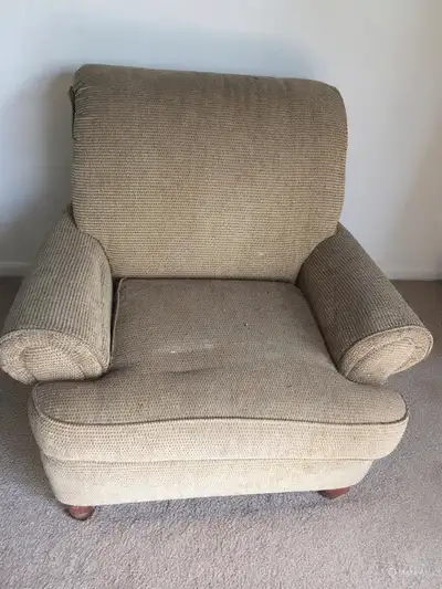 This armchair has been well-loved and shows signs of wear, making it a comfy addition to any room th...
