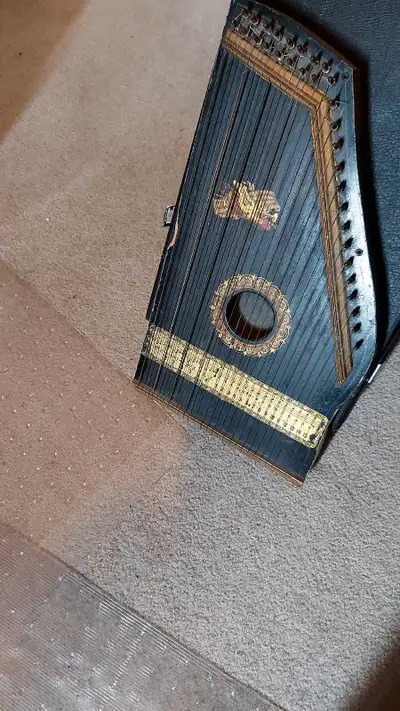 Very old zither. Patent date of 1896 and it looks to be of that era. Condition consistent with age....